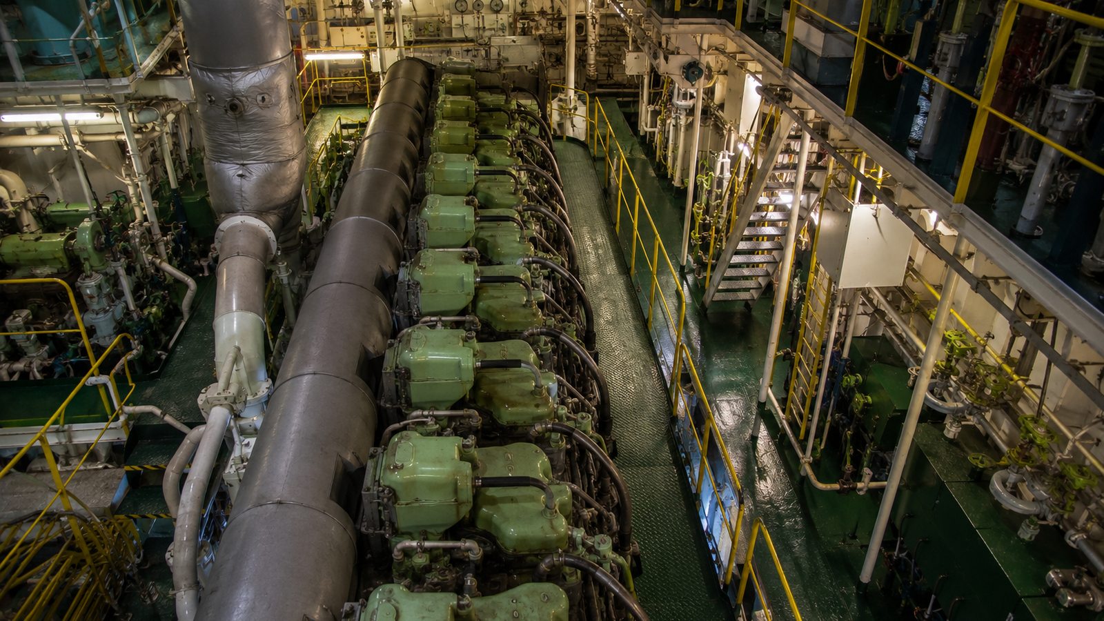 Marine engineer working on a ship's main engine in the engine room — technical and engineering services